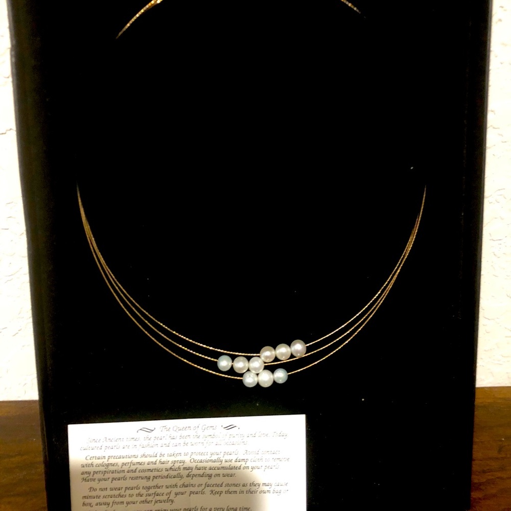 Triple strand gold and floating pearl necklace.